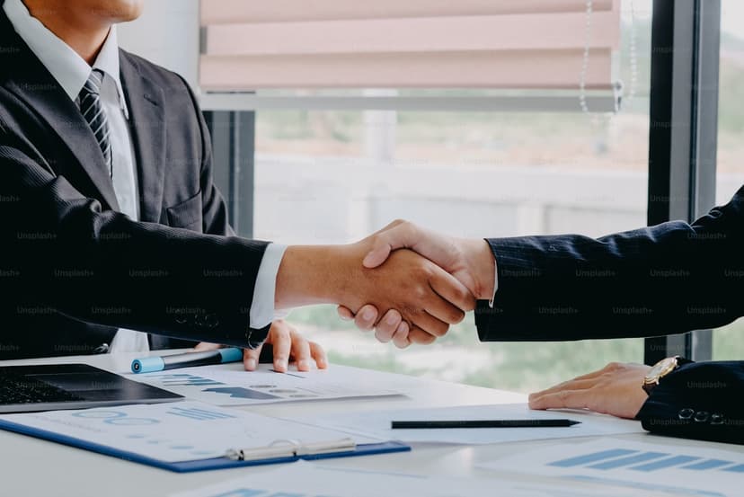 Recruitment professionals greeting each other across a desk